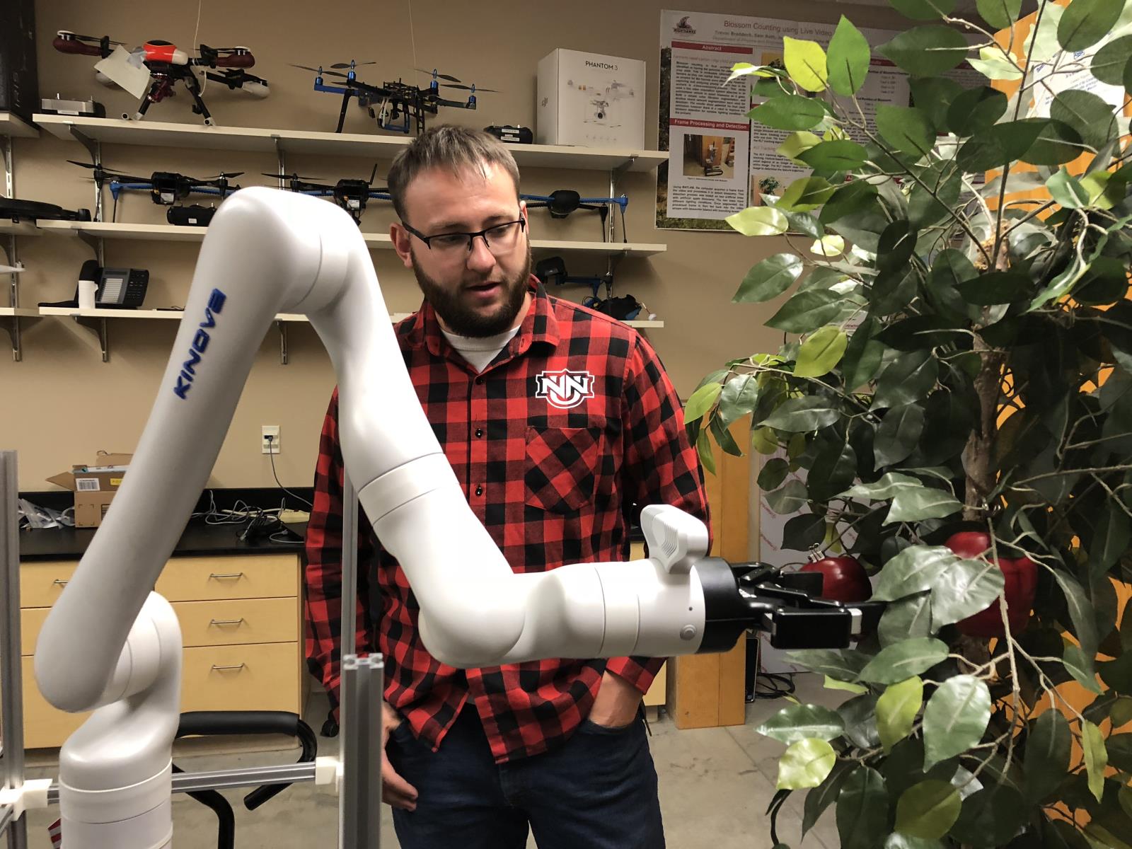 Northwest Nazarene University engineering student Colton Burr demonstrates OrBot, a fruit harvesting robot prototype, for Idaho Farm Bureau Federation employees May 6. 