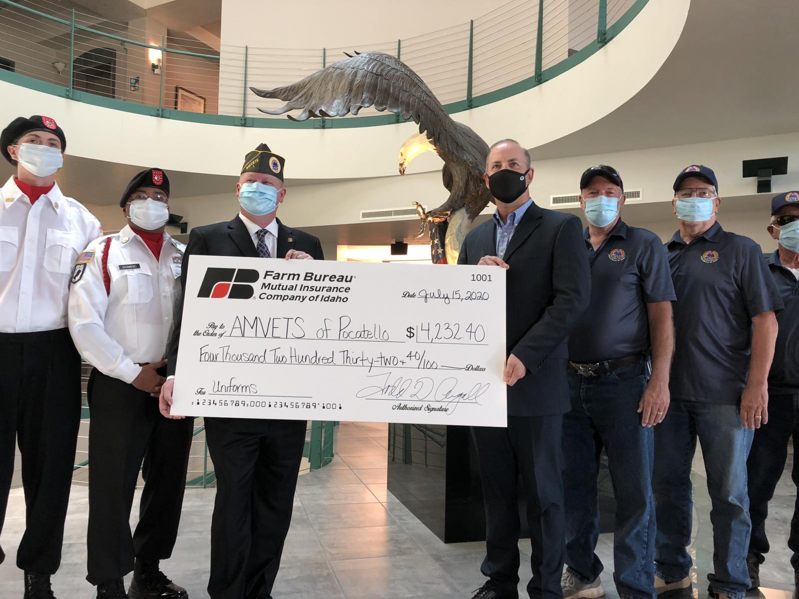 Farm Bureau Mutual Insurance Co. of Idaho CEO Todd Argall, center right, presents a check for $4,232 to AMVETS Pocatello Commander Lance Kolbet, center left, July 15. The money will be used to help the local AMVETS chapter start its honor guard. 