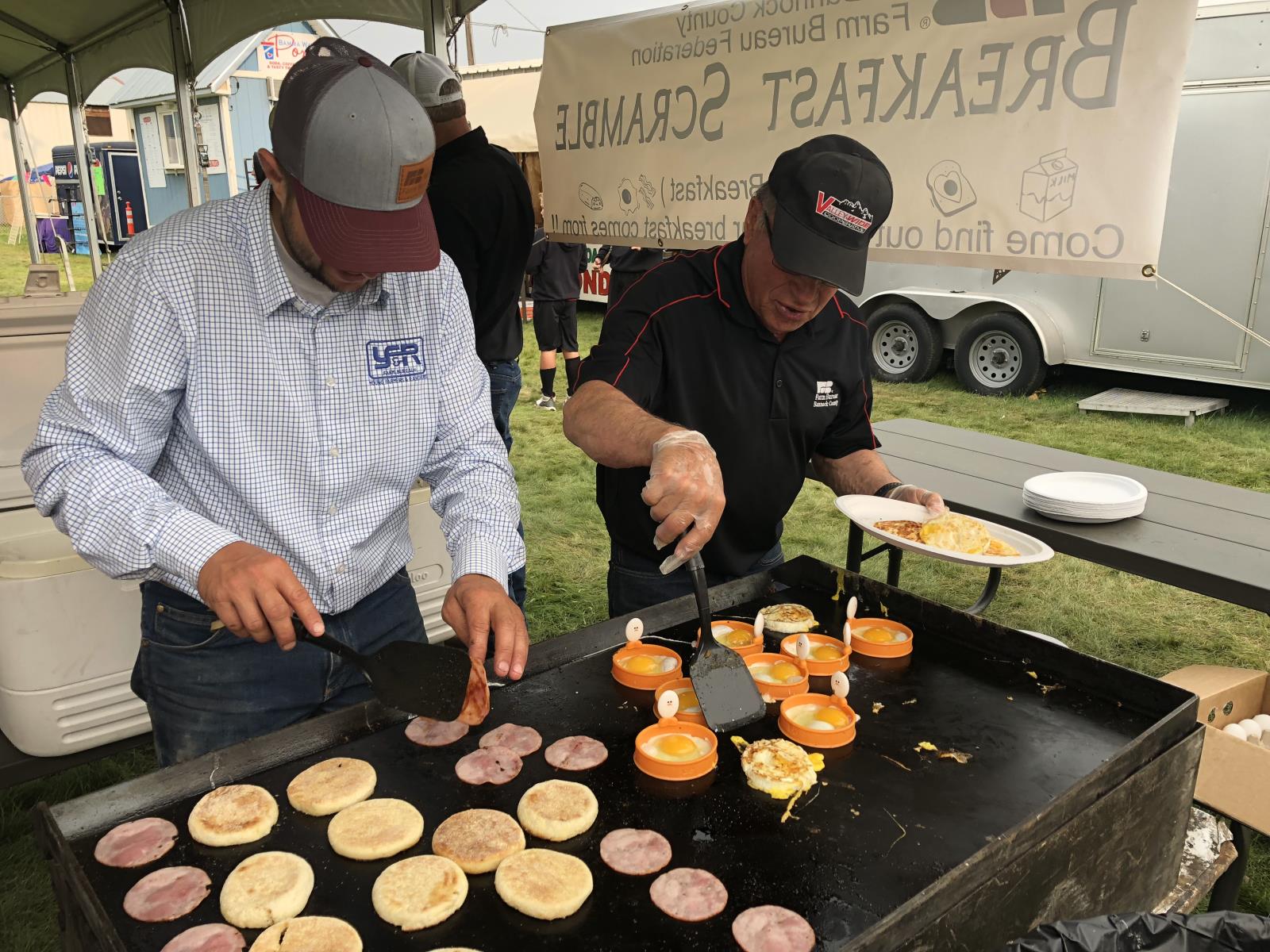 Bannock County Farm Bureau board members Kyle Wade, left, and Craig Smith cook up some of the ingredients for breakfast sandwiches that were provided free to participants of BCFB’s annual Breakfast Scramble, which took place Aug. 6 during the Bannock County Fair in Downey.