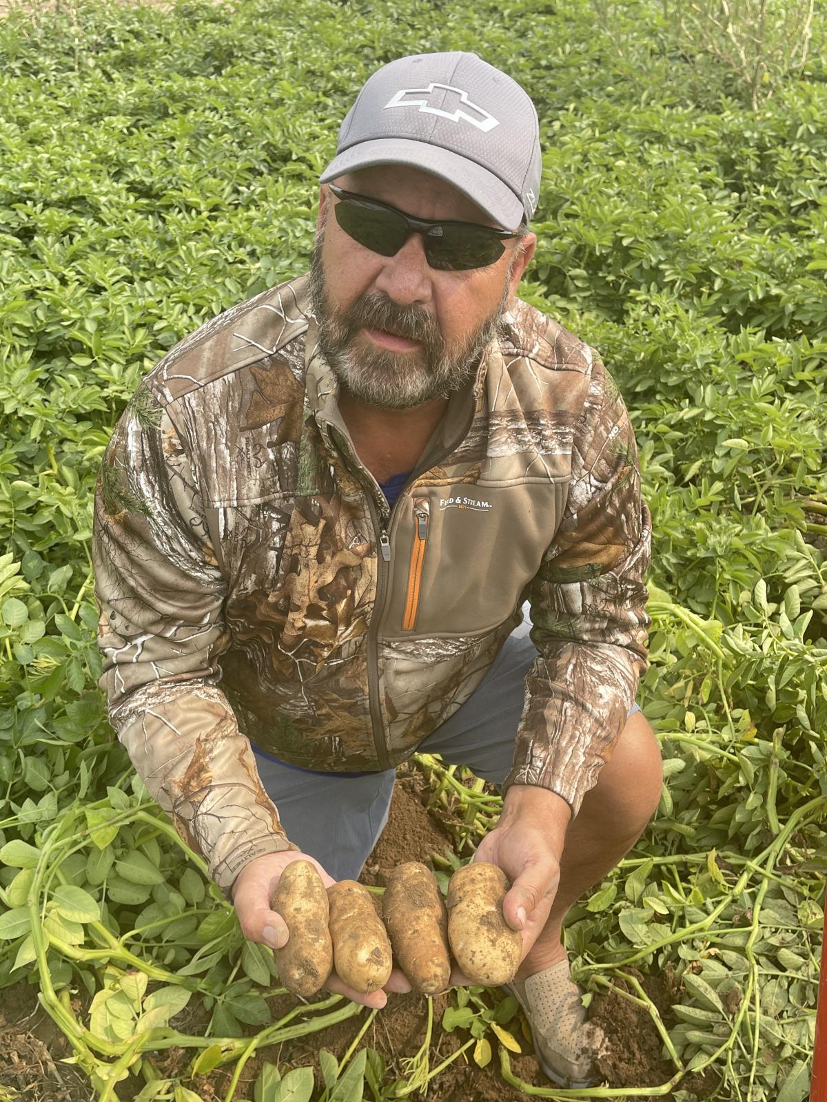 American Falls farmer Jim Tiede holds up Ranger Russet spuds from one of his fields on Aug. 24.