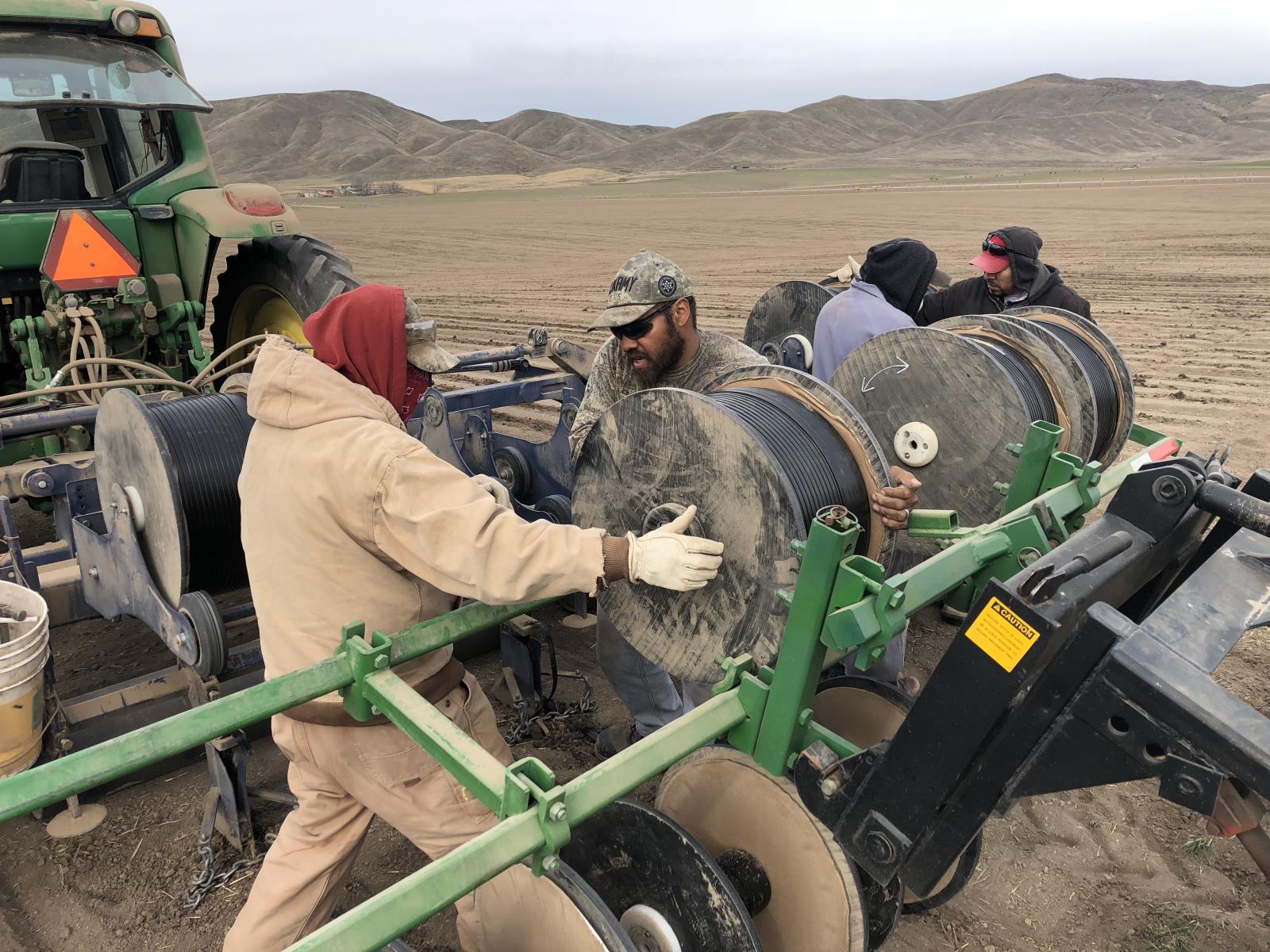 Farm workers earlier this spring prepare to lay drip irrigation tape in a field near Weiser will be planted to onions. 